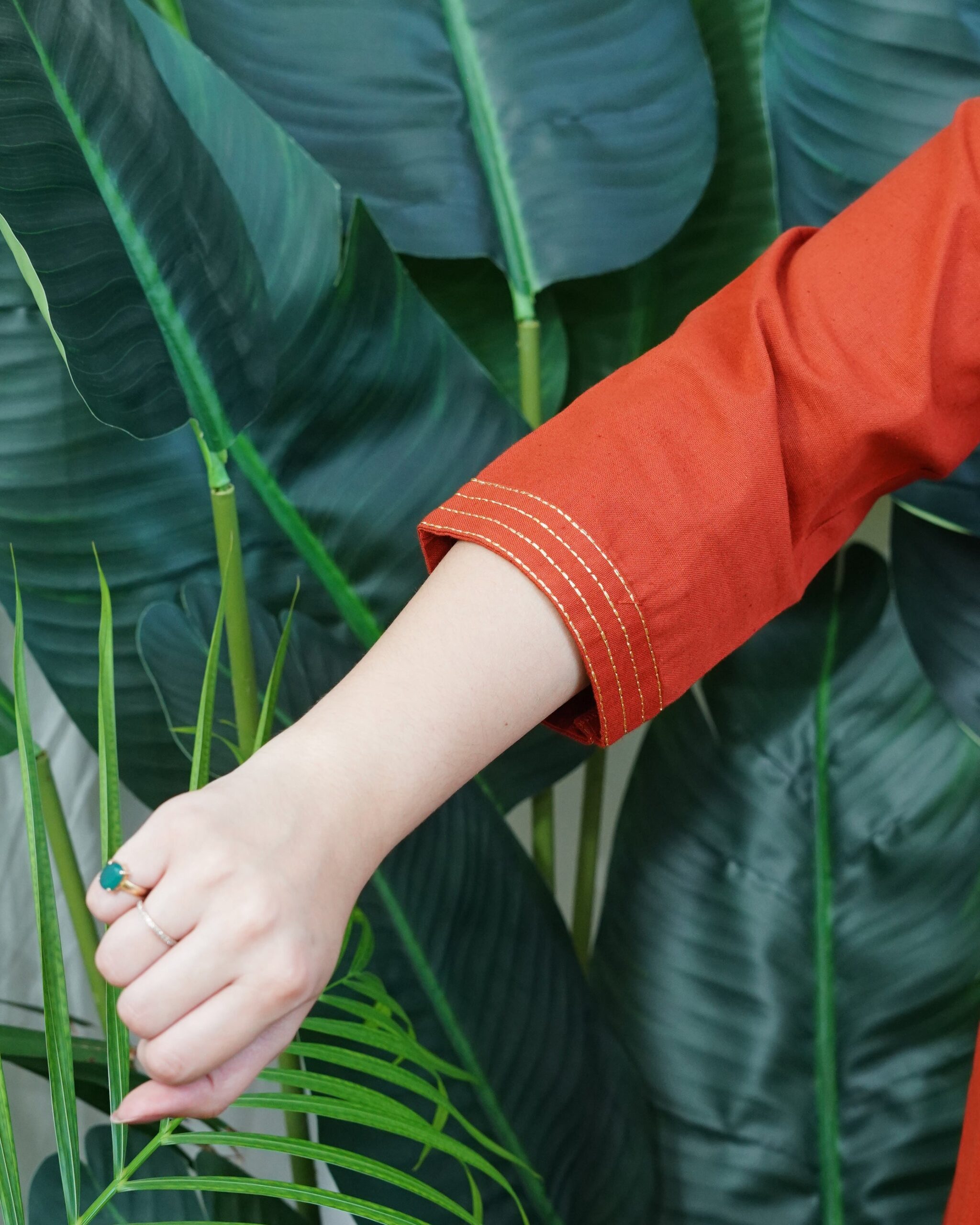 A-line Kurta with Pockets Sona Mart3 Model wearing a solid rust-colored A-line kurta with V-neck embroidery and side pockets, paired with black pants.