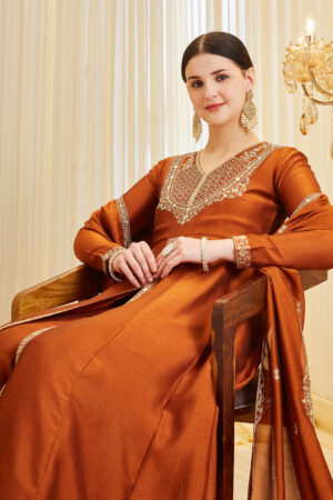 Model wearing a premium orange silk embroidered Anarkali kurta featuring a V-neck and full sleeves, paired with a matching dupatta, perfect for festive wear and weddings.