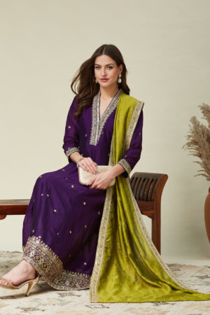 Model wearing a luxurious violet embroidered silk Anarkali kurta featuring a V-neck and 3/4 sleeves, paired with a matching dupatta, perfect for weddings and festive occasions.