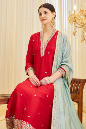 Close up of intricate V-neck embroidery on vibrant red silk ethnic wear.