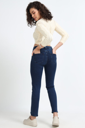 Close up of 5-pocket design and button closure on dark blue denims.