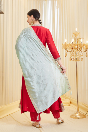 Close up of intricate V-neck embroidery on vibrant red silk ethnic wear.