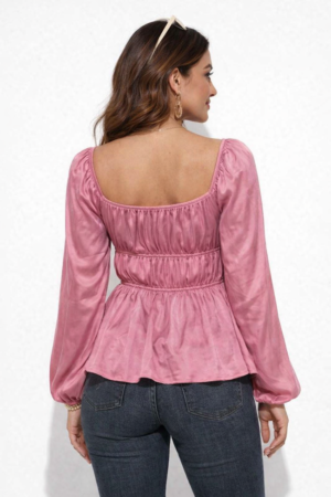 Close up of square neckline and smocked detailing on a pink viscose top