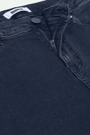 Full length view of stretchable ankle-length indigo jeans for women.