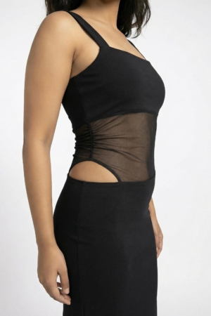 Close up of slanted mesh midriff and side cutout on black evening gown